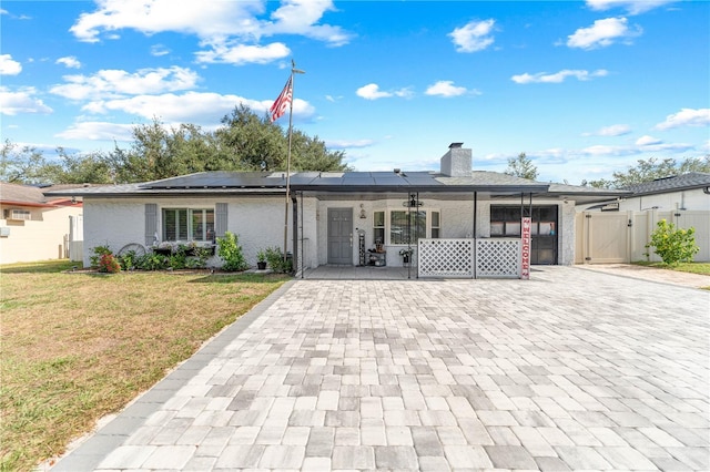 back of property featuring solar panels, a porch, and a lawn