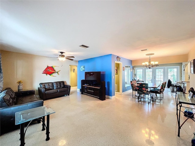 living room featuring ceiling fan with notable chandelier and french doors