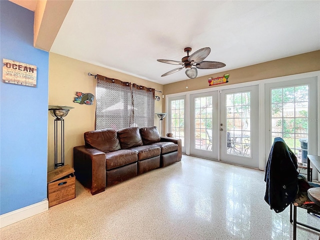 living room featuring ceiling fan and french doors