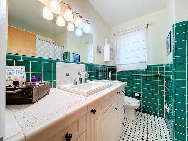 bathroom with tile patterned flooring, vanity, toilet, and tile walls