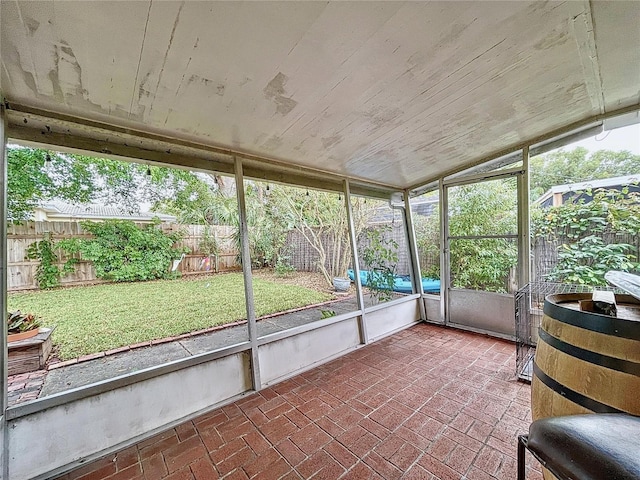 unfurnished sunroom featuring vaulted ceiling