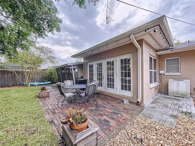 view of patio with french doors and a sunroom