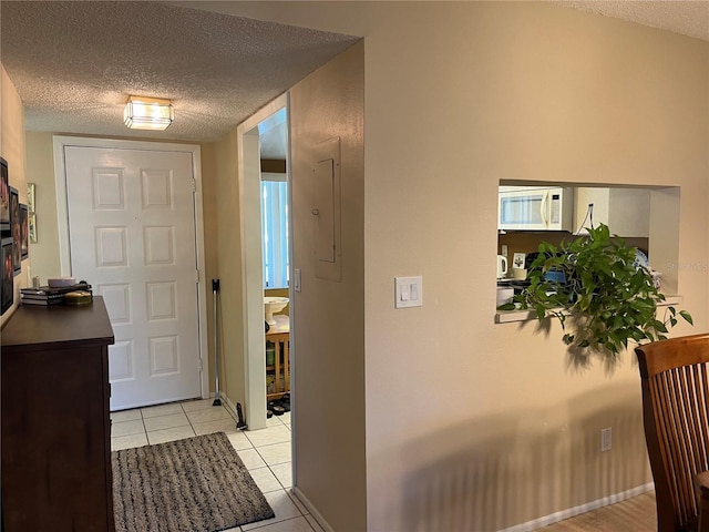 foyer entrance with light tile patterned floors and a textured ceiling