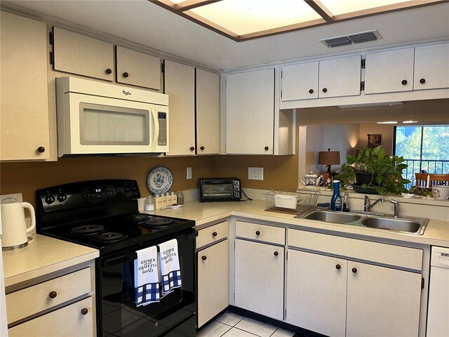 kitchen with sink, light tile patterned floors, and white appliances