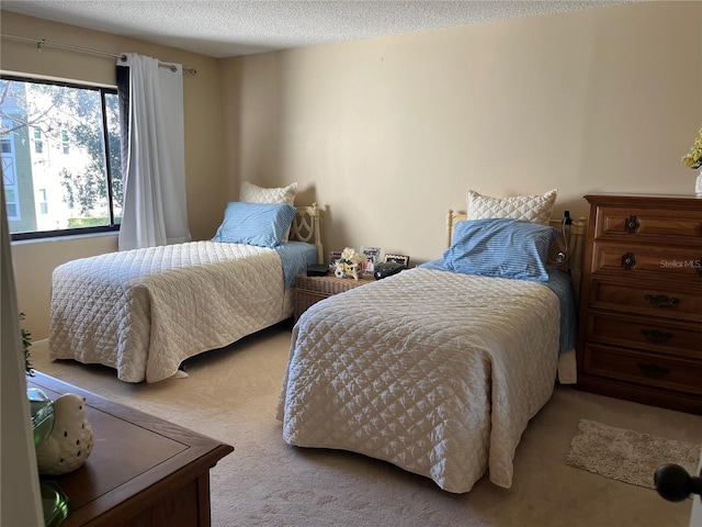 bedroom featuring a textured ceiling and light colored carpet