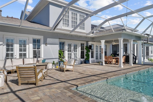 rear view of property featuring a lanai, ceiling fan, a patio area, an outdoor hangout area, and french doors