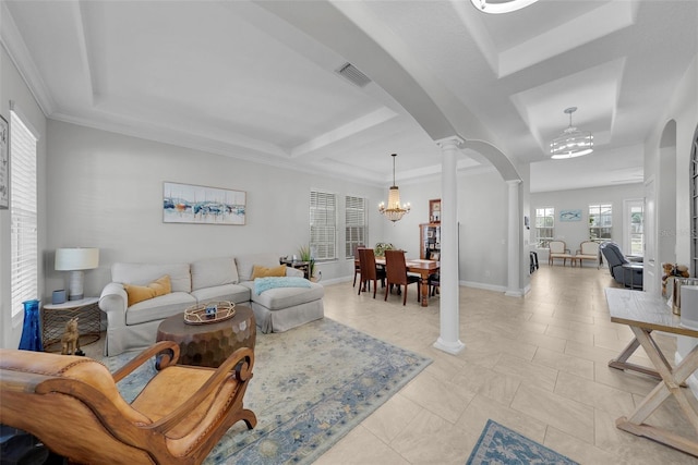 tiled living room featuring crown molding, a tray ceiling, a chandelier, and decorative columns