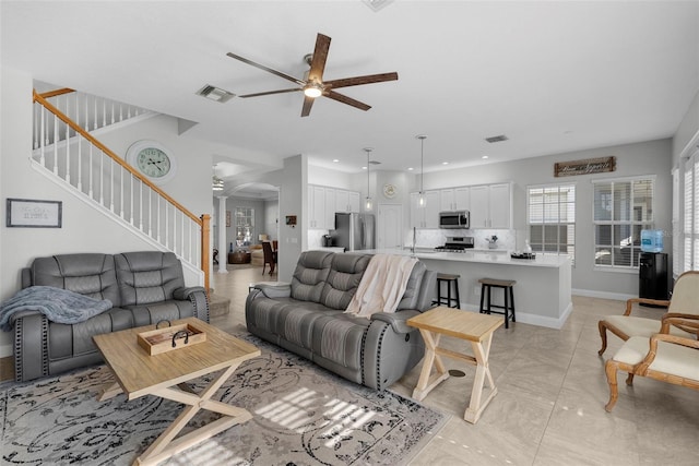 living room featuring ceiling fan and sink