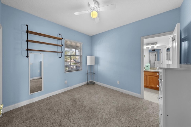 unfurnished bedroom featuring light carpet, ensuite bath, and ceiling fan