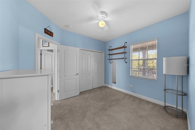 unfurnished bedroom featuring light carpet, a closet, and ceiling fan