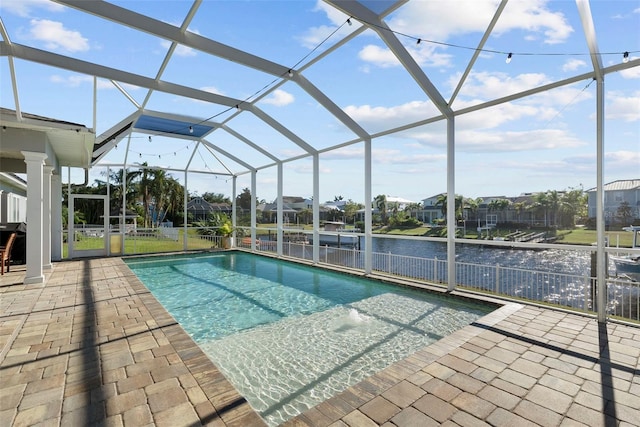 view of swimming pool featuring a patio area, a water view, and glass enclosure