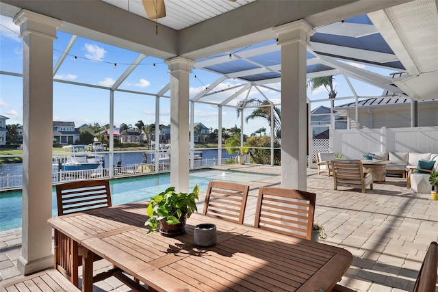 view of patio / terrace with a water view, an outdoor living space, and a lanai