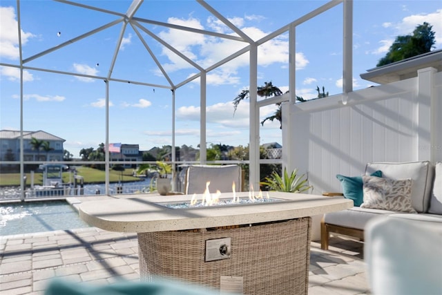 view of patio / terrace featuring a lanai, a swimming pool, pool water feature, and an outdoor fire pit