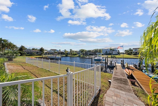 view of dock with a water view and a lawn