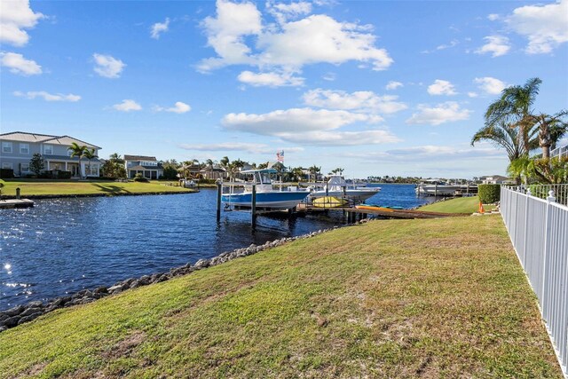 dock area with a lawn and a water view