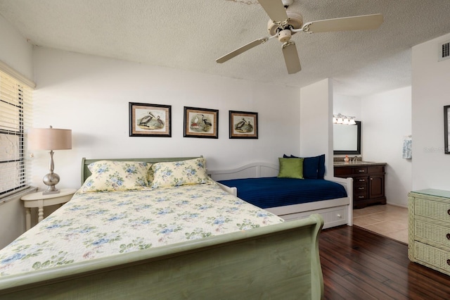 bedroom featuring dark hardwood / wood-style floors, ceiling fan, and a textured ceiling