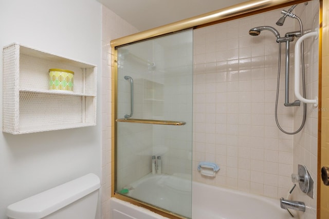 bathroom featuring bath / shower combo with glass door and toilet