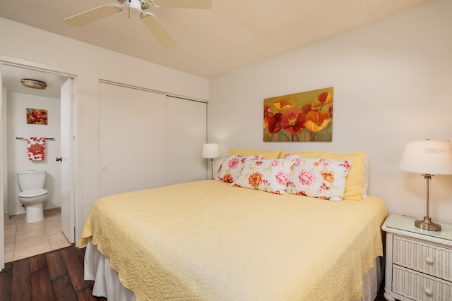 bedroom featuring ceiling fan, dark wood-type flooring, connected bathroom, and a closet