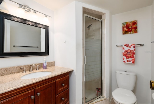 bathroom with vanity, toilet, and an enclosed shower