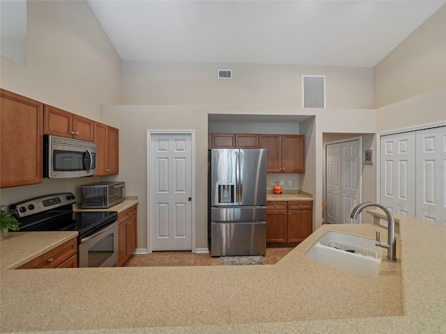 kitchen featuring appliances with stainless steel finishes, sink, and a high ceiling