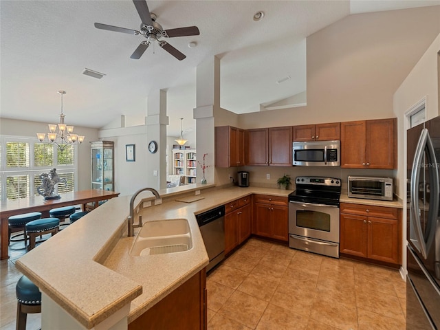 kitchen featuring sink, hanging light fixtures, kitchen peninsula, and appliances with stainless steel finishes