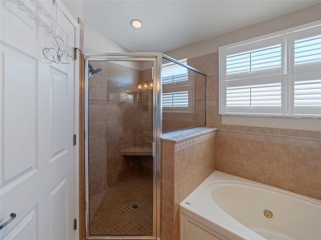 bathroom featuring separate shower and tub and a textured ceiling