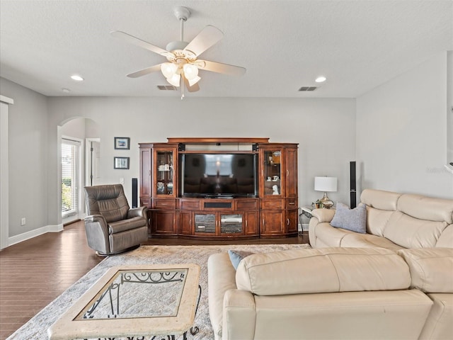 living room with hardwood / wood-style floors, ceiling fan, and a textured ceiling