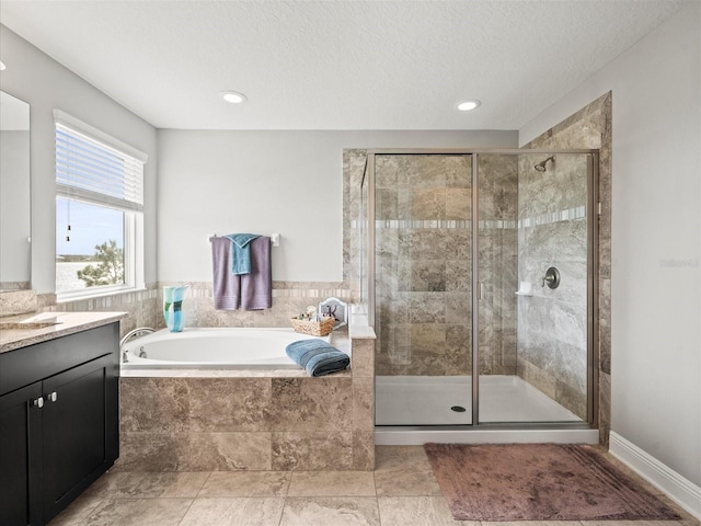 bathroom with a textured ceiling, vanity, and independent shower and bath