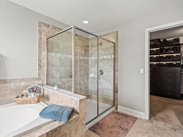 bathroom with tile patterned flooring, shower with separate bathtub, and a textured ceiling