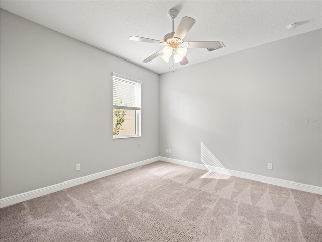 carpeted spare room with ceiling fan and a textured ceiling