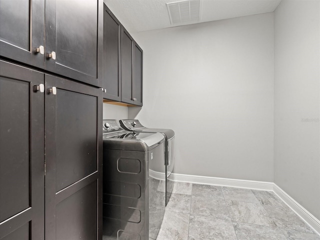 laundry area with washing machine and dryer and cabinets