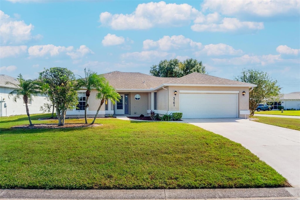 single story home with a front yard and a garage