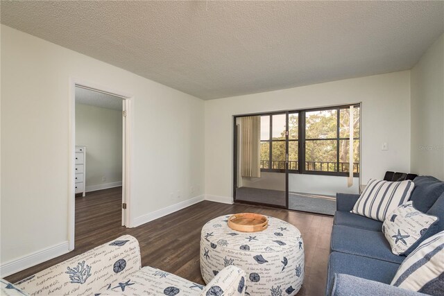 living room with a textured ceiling and dark hardwood / wood-style floors