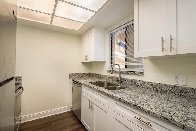 206 Tarpon Pt, Tarpon Springs, FL 34689 - kitchen with a sink, stainless steel appliances, baseboards, dark wood-style flooring, and light stone counters