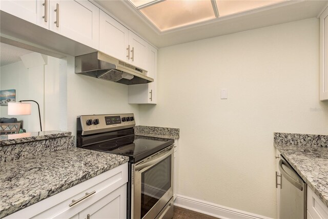 kitchen with light stone countertops, white cabinetry, and appliances with stainless steel finishes