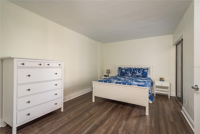 bedroom featuring a textured ceiling and dark hardwood / wood-style floors