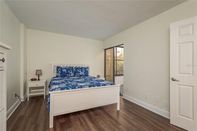 bedroom featuring dark hardwood / wood-style flooring and a textured ceiling