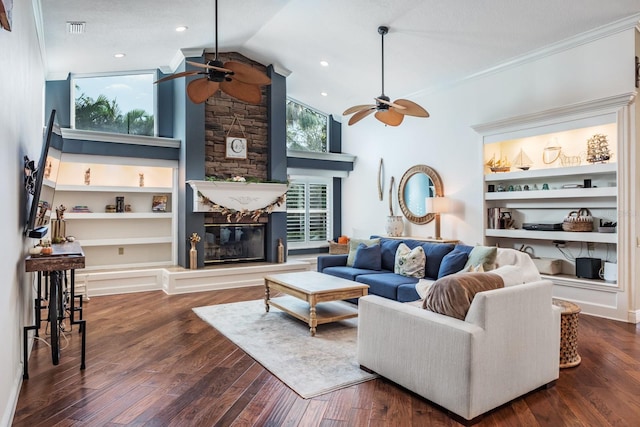 living room featuring dark hardwood / wood-style floors, a stone fireplace, and plenty of natural light