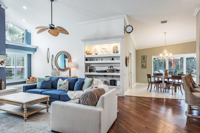 living room featuring plenty of natural light, ornamental molding, ceiling fan with notable chandelier, and hardwood / wood-style flooring