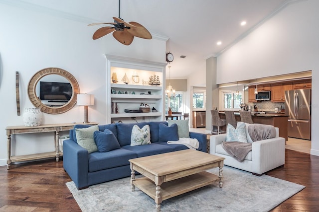 living room featuring dark hardwood / wood-style floors, ornamental molding, ceiling fan with notable chandelier, and high vaulted ceiling