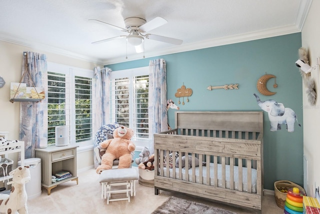 carpeted bedroom with a nursery area, crown molding, and ceiling fan