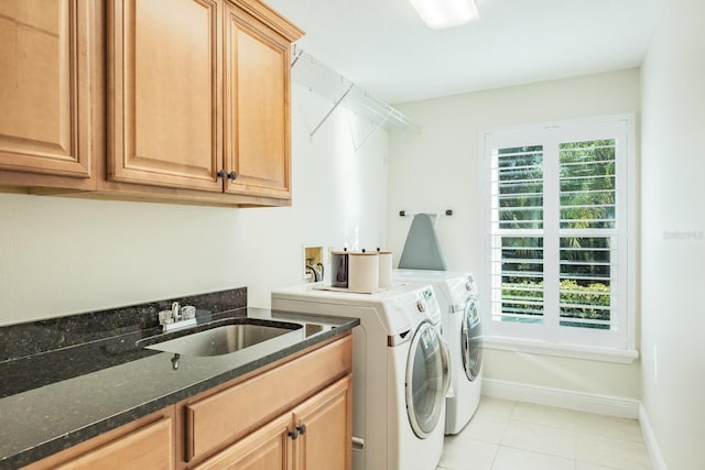 washroom featuring washer and dryer, cabinets, a healthy amount of sunlight, and sink