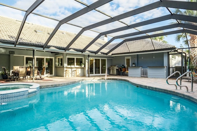 view of pool featuring an in ground hot tub, glass enclosure, a patio area, and a grill