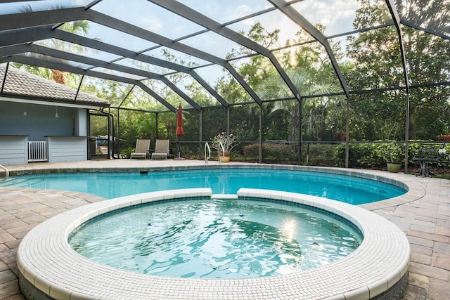 view of pool featuring a lanai, an in ground hot tub, and a patio