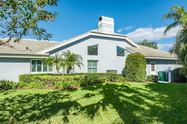 rear view of house featuring a yard and central air condition unit