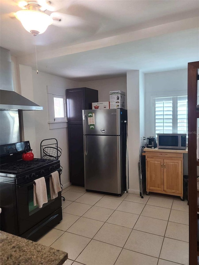 kitchen featuring wall chimney exhaust hood, light tile patterned flooring, and appliances with stainless steel finishes