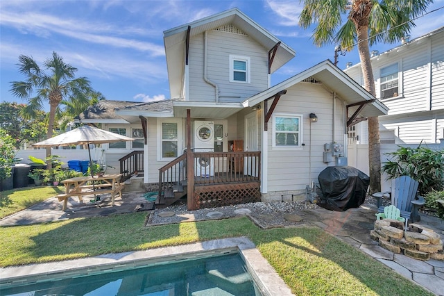 back of property with a patio area and a yard