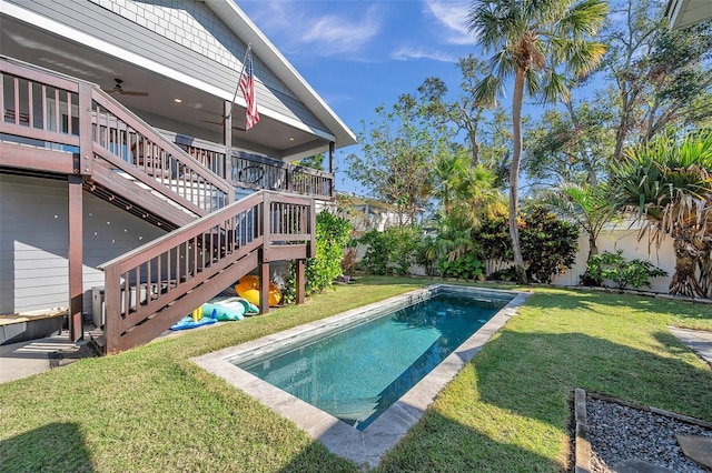 view of pool featuring ceiling fan and a yard