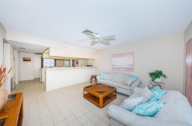 living room with visible vents, a ceiling fan, a textured ceiling, and light tile patterned flooring