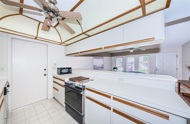 kitchen with white cabinets, black microwave, light countertops, and electric stove